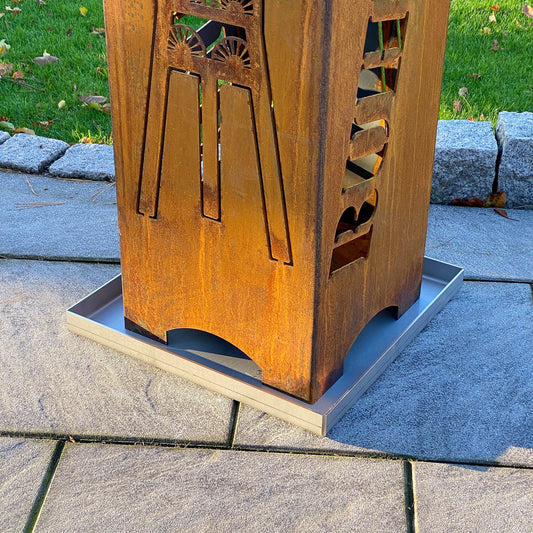 Fokus vom Bild ist auf die Edelstahl Ascheschale in 400 mal 400 Millimeter gerichtet. Diese steht unter einer Ruhrpott Feuertonne