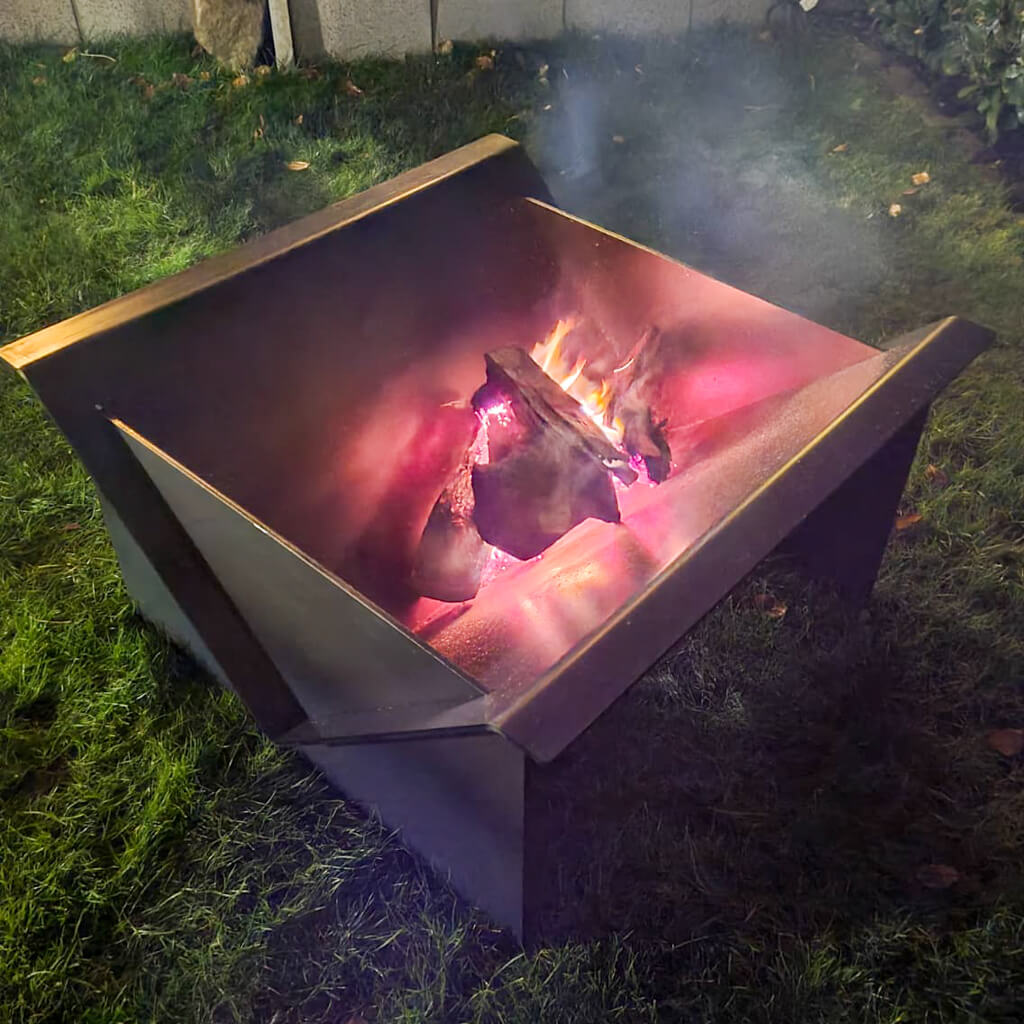 120 kg schwerer Feuertisch von Rostige Aussichten in Walzblau mit brennenden Holzscheiden